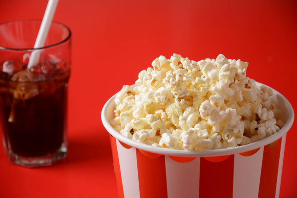 Buckets with delicious popcorn on red background. Spilled popcorn  - Foto, imagen