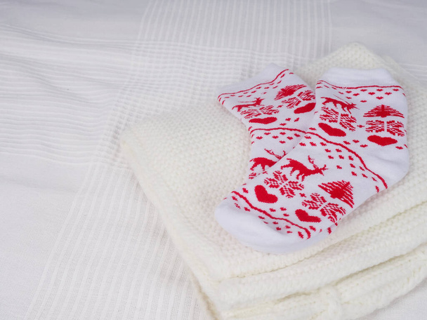 Noel çorapları kırmızı beyaz bir yatakta yeni yılı bekliyor, tasarım için yer, seçici odaklanma- - Fotoğraf, Görsel