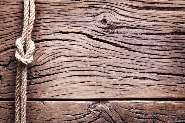 Sailor's knot over old wooden background. - Zdjęcie, obraz
