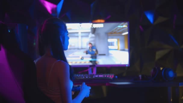 Jeune femme sexy jouant à un jeu dans un club de jeu - se retourne et joue avec un chewing-gum bulle - Séquence, vidéo