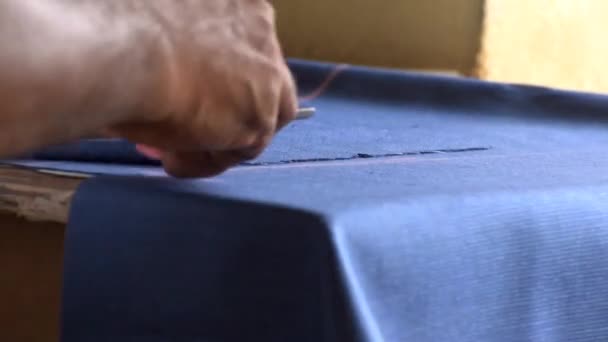 Tailor marking the fabric cloth with a chock piece. - Felvétel, videó