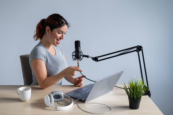 Egy bájos női rádiós műsorvezető élőben közvetít egy laptopon. Online rádiókoncepció - Fotó, kép