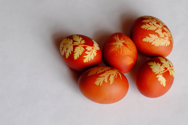 Painted Easter eggs on a white background. Floral pattern on a red eggshell. Festive food. - Fotoğraf, Görsel