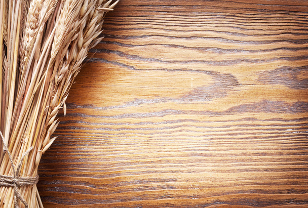 Ears of wheat on old wooden table. - Fotografie, Obrázek