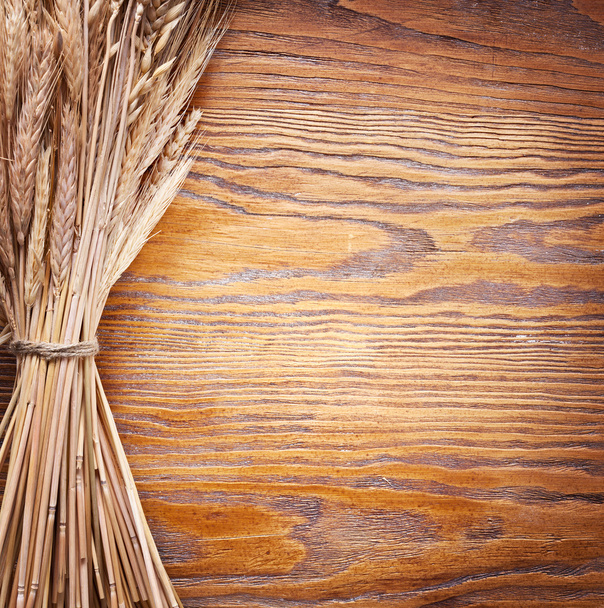 Ears of wheat on old wooden table. - Zdjęcie, obraz