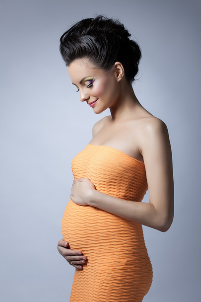 Beautiful elegant pregnant woman posing in studio - Fotografie, Obrázek
