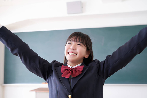 Egy japán középiskolás lány, aki az osztályteremben táncol. - Fotó, kép
