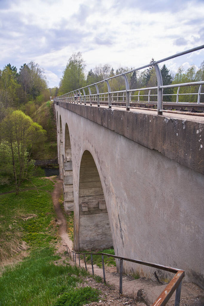 Most kolejowy w miejscowości Tokarevka. Obwód kaliningradzki. Most nad rzeką czerwony - Zdjęcie, obraz