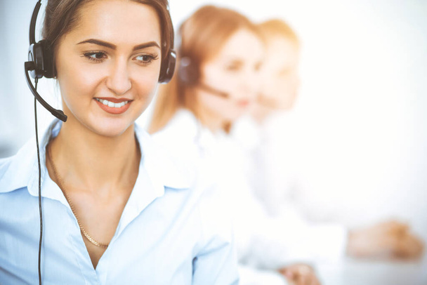 Call center. Focus on beautiful business woman in headset - Fotó, kép