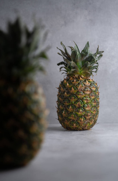 Rijp ananas op een grijze achtergrond. rauw fruit - Foto, afbeelding