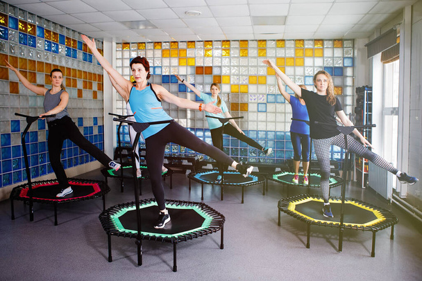 Grupo de mulheres fazendo fitness em trampolins no ginásio. - Foto, Imagem