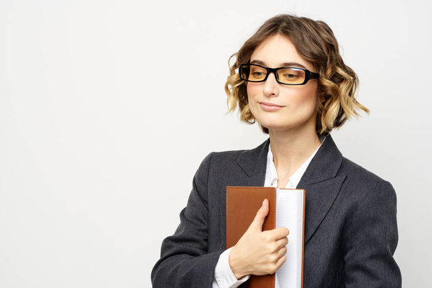 Femme au travail avec livre à la main lumière arrière-plan classique costume lunettes tête - Photo, image