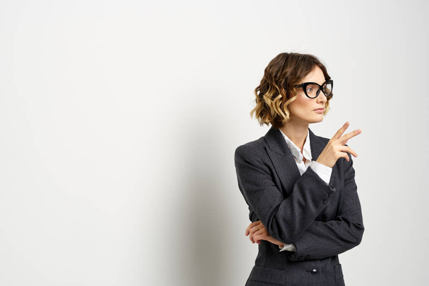selbstbewusste Geschäftsfrau im Anzug gestikuliert mit Händen im Hintergrund - Foto, Bild