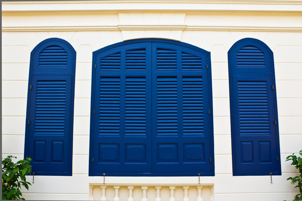 クリーム色の壁に青い窓シャッター - 写真・画像