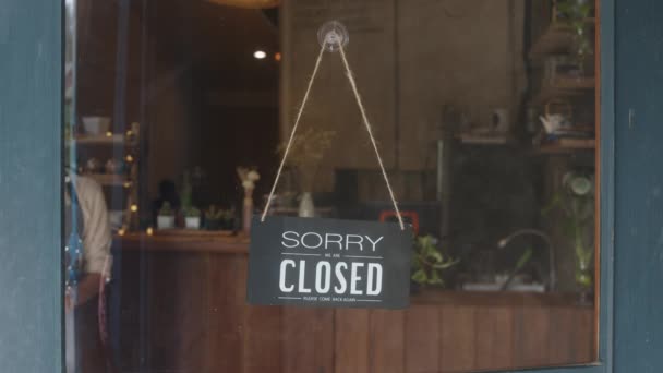 Young Asia manager girl changing a sign from closed to open sign on door cafe looking outside waiting for clients after lockdown. Owner small business, food and drink, business reopen again concept. - Footage, Video
