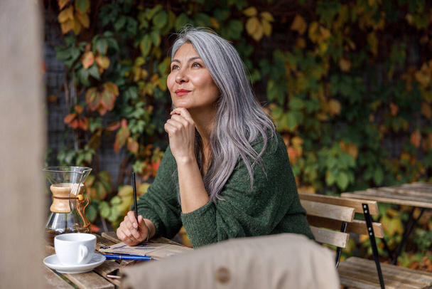 Dojrzałe blado włosy stylowe kobieta styl życia portret na zewnątrz w pobliżu kawiarni - Zdjęcie, obraz