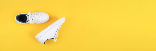 White sports shoes, sneakers with shoelaces on a yellow background. Sport lifestyle concept Top view Flat lay Banner. - Foto, Bild