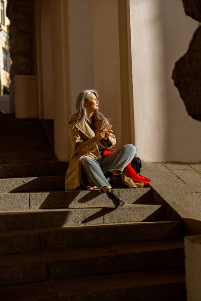 Mature pale hair stylish woman lifestyle portrait outdoors in city - Foto, Imagen