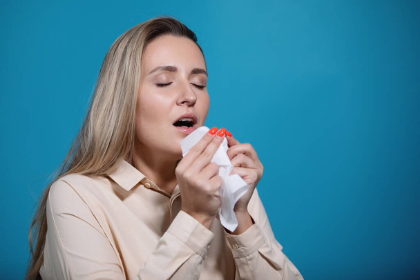 コロナウイルスの流行。女は鼻を吹き、くしゃみをしてハンカチに咳をする。インフルエンザ、発熱、パンデミックの症状. - 写真・画像