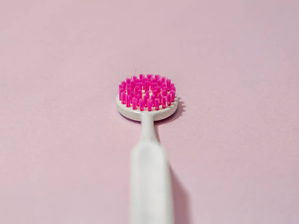 Biała plastikowa szczotka z fioletowymi szczecinami do czyszczenia języka. Produkt do higieny jamy ustnej i pielęgnacji - Zdjęcie, obraz