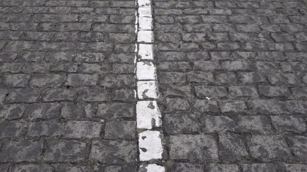 Cobblestone pavimentado textura de la carretera con marca blanca de la carretera - Metraje, vídeo