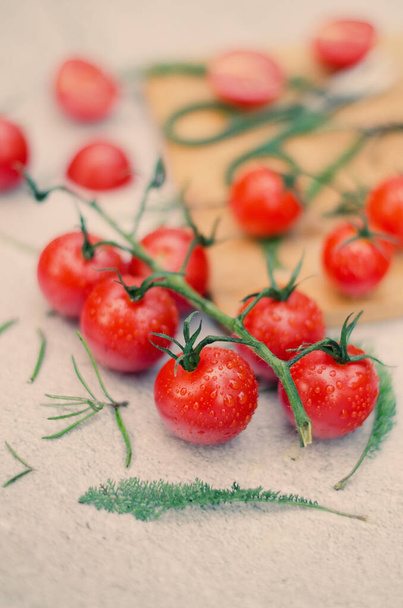 Food photography of fresh cherry tomatoes with herbs on a vintage background at table close up.  - Фото, изображение