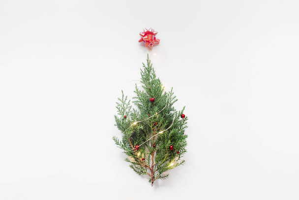 Christmas tree on white background. Trendy minimal New Year concept. Flat lay, top view, copy space. - Photo, image