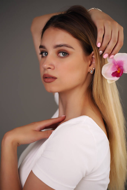 Beauty Portrait. Beautiful Stylish Girl with Orchid Flower. Perfect Face Skin. Healthy hair. - Foto, Imagem