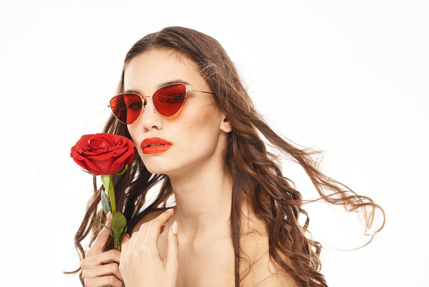 Bruna ragazza con rosa rossa e occhiali da sole spalle nude - Foto, immagini