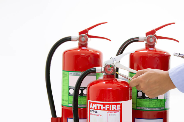 Brandschutztechnik überprüft den roten Feuerlöscher-Tank in den Gebäudekonzepten zur Notfall- und Sicherheitsrettung und Brandschutzausbildung. - Foto, Bild