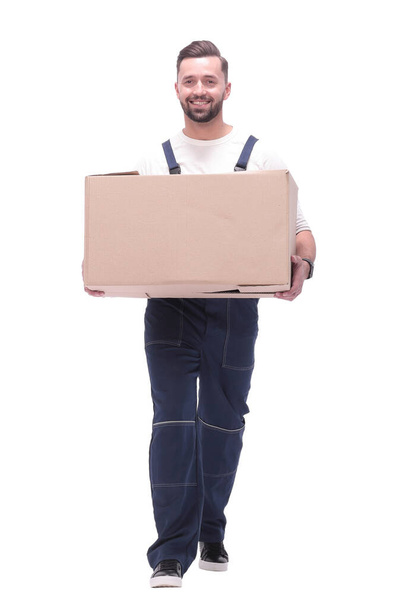 in full growth. smiling man carries a large cardboard box - Φωτογραφία, εικόνα