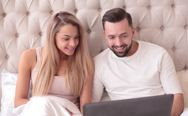 νεαρό ζευγάρι που περιηγούνται το αγαπημένο τους Vidio στο laptop τους - Φωτογραφία, εικόνα