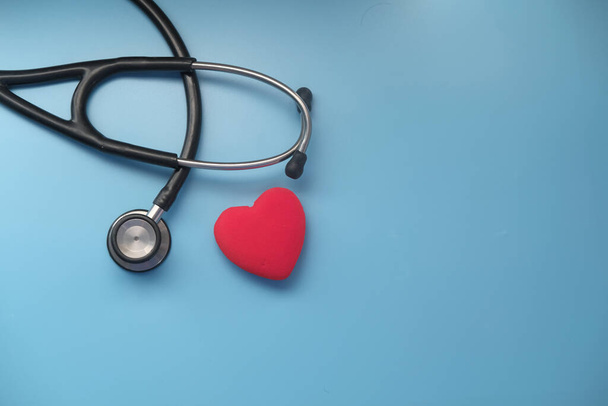 heart shape symbol and stethoscope on blue background  - Фото, изображение