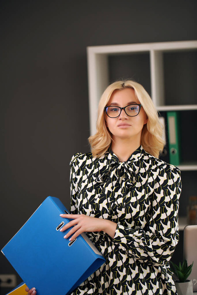 Attractive young businesswoman with day planner in office lobby - Fotó, kép