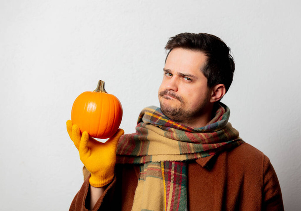 Style man in coat and scarf with pumpkin on white background - Foto, Bild