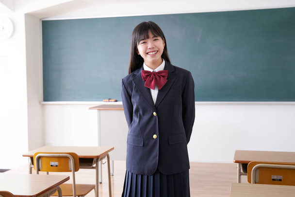 Sınıfta gülümseyen bir Japon liseli kız var. - Fotoğraf, Görsel