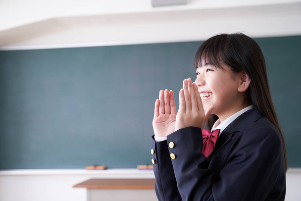 Un giapponese scuola media ragazza applausi nella sua classe - Foto, immagini