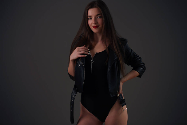 Sexy brunette girl in a black jumpsuit with a big beautiful ass - Fotó, kép