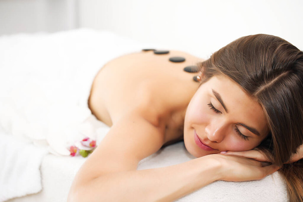 Young beautiful woman receiving spa treatment in spa beauty salon. Wellness massage. Beauty salon. - Фото, изображение
