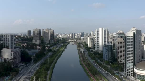 Vista dos Pinheiros Marginal com o Rio Pinheiros e edifícios modernos em São Paulo, Brasil, avançando - Filmagem, Vídeo