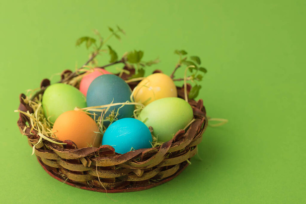 Easter basket with eggs decorated with a sprig with green young leaves - Fotó, kép