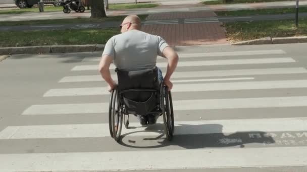 Gehbehinderter Mann im Rollstuhl überquert Straße - Filmmaterial, Video