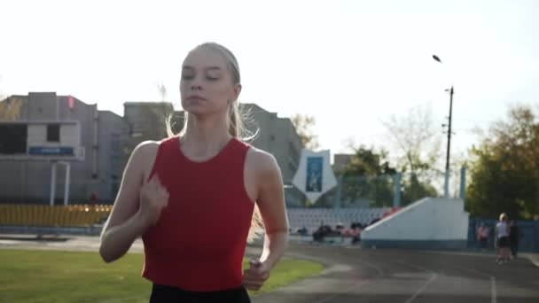 junger sportlicher kaukasischer Fitnessläufer in Sportbekleidung läuft auf Stadionbahn - Filmmaterial, Video
