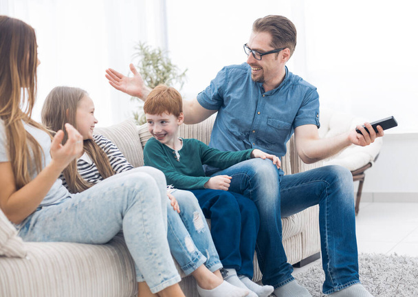 cheerful family sitting on the couch in the living room - Photo, Image