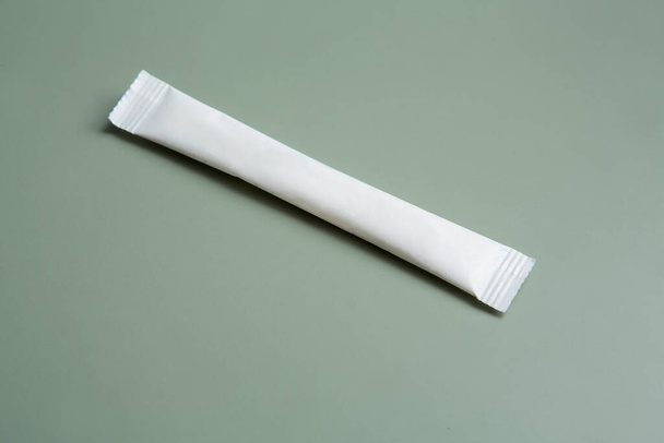 Цукровий мішок білий довгий тонкий пакет на зеленому сірому фоні
 - Фото, зображення