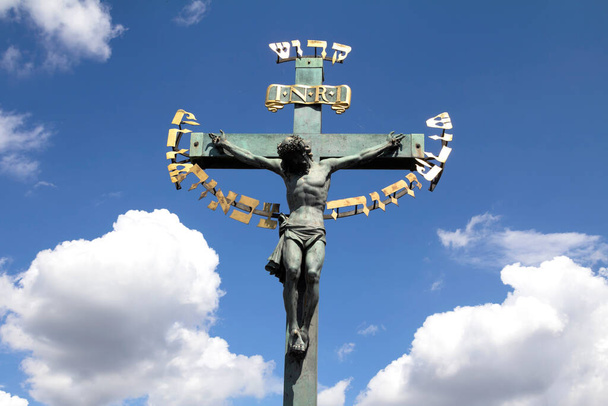 Статуя распятия XVII века с ивритской надписью в Карловом мосту Прага, Чехия - Фото, изображение