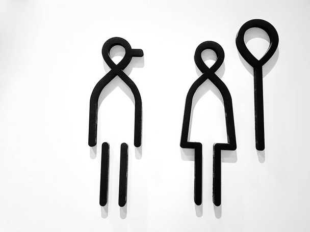 Czarne symbole toalet dla mężczyzn i kobiet na białym murze - Zdjęcie, obraz