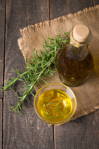 Rosemary oil on wooden background. Natural food concept.  - Фото, зображення