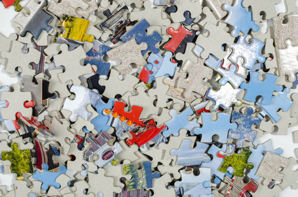 Pieces of a multicolored puzzle lie chaotically in a large pile - Foto, immagini