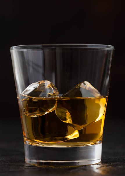 Glass with ice cubes of scotch whiskey on black, Macro - 写真・画像